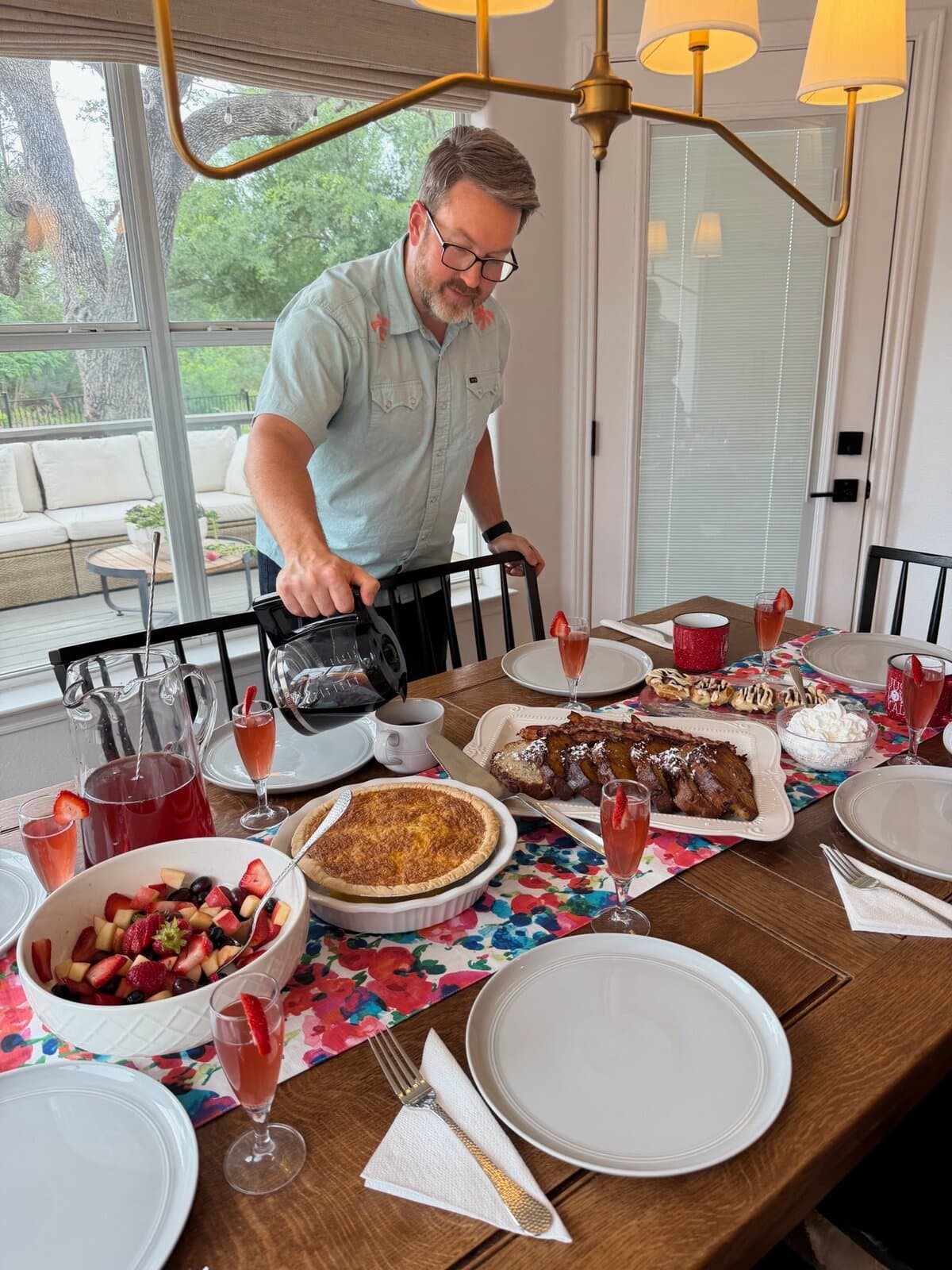 The Queen for a Day kit spread out on a dining table with dad pouring coffee